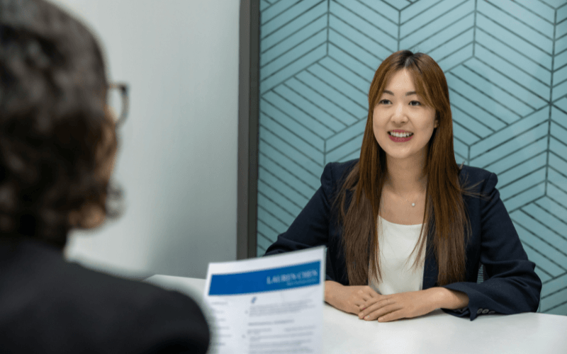 不動産会社で書類を渡される女性
