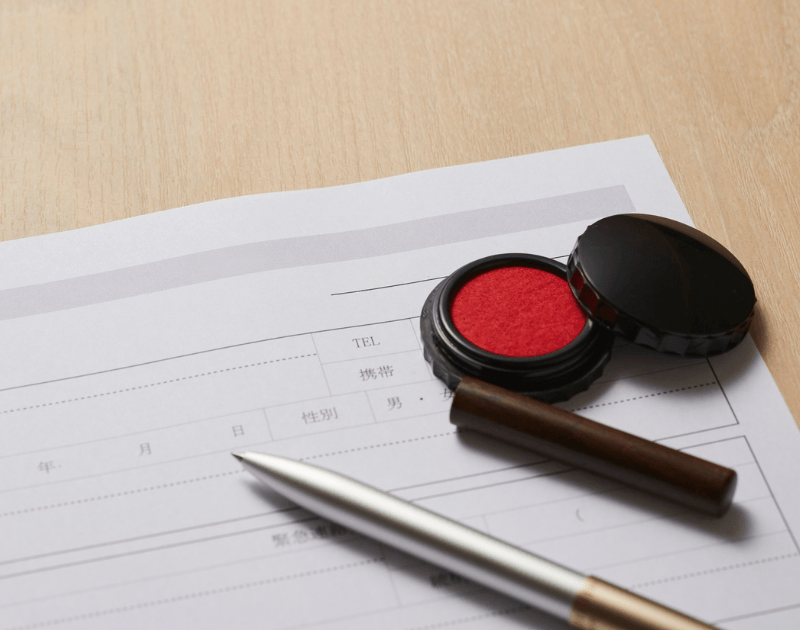 実印と朱肉、書類が置かれた登記手続きのイメージ